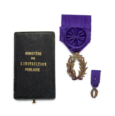 un ruban violet et une médaille sur un livre noir entouré d'un ruban violet