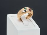 a close up of a gold ring with various colored stones