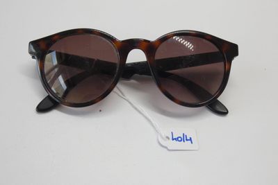 gros plan d'une paire de lunettes de soleil sur une surface blanche
