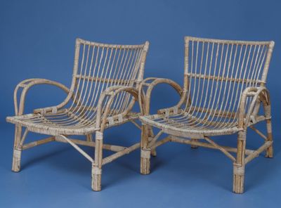 pair of wicker lounge chairs on a blue background