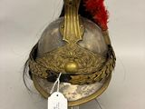 un vieux casque surmonté d'une plume rouge