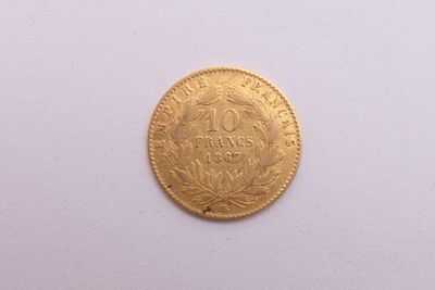 gros plan d'une pièce d'or sur une surface blanche