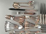 a lot of silverware on a table with spoons and forks