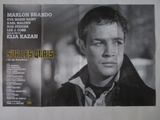 une vieille affiche de cinéma représentant un homme en veste noire