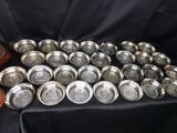 une pile d'assiettes en argent posée sur une nappe noire