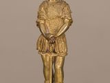 une figurine en or représentant un homme portant un chapeau et une robe
