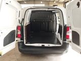the back of a white van with its doors open in a garage
