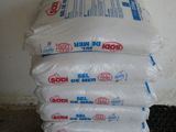 une pile de sacs de graines noires à côté d'une pile de graines noires