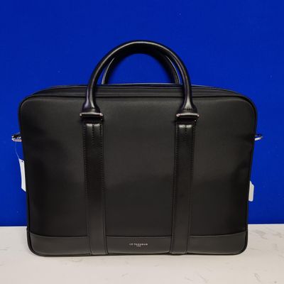 a black briefcase sitting on top of a table next to a blue wall