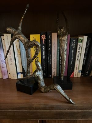 a statue of a man and a woman on a book shelf
