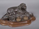a statue of a lion sitting on a tray with tea cups
