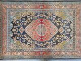 an antique persian rug with a blue background and a red center
