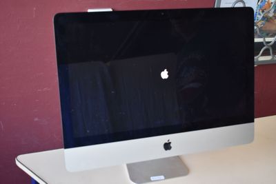un écran d'ordinateur posé sur un bureau blanc