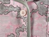 the jacket is pink and grey with a pattern on it
