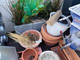 a pile of pots and a watering can on the ground