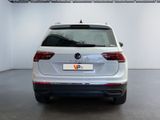 the rear end of a white volkswagen v - cross parked in a garage