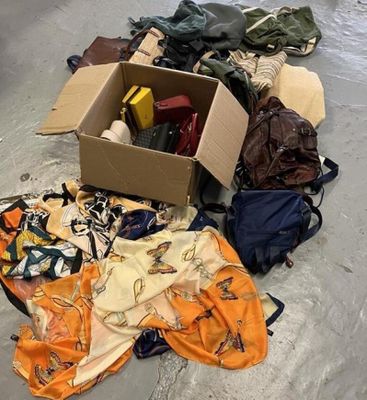 une boîte remplie de vêtements et d'autres objets posée par terre