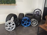 wheels and tires are lined up on the floor in a room