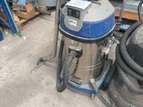 un aspirateur posé sur le sol du garage