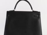 a black leather handbag on a white background