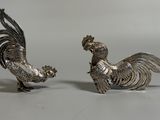 paire de figurines de coqs plaquées argent sur fond blanc