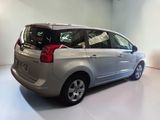 a silver minivan parked in a room with a white floor