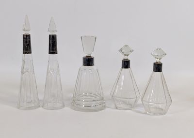 quatre bouteilles en verre transparent avec des bouchons noirs et un bouchon noir