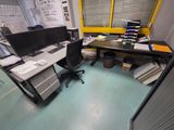 un bureau avec deux écrans d'ordinateur et une chaise dans un coin