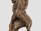 a bronze statue of two men wrestling on a wooden base