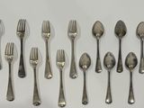 a lot of silver spoons and forks on the table