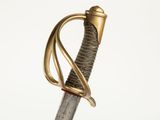 une vieille épée avec un manche en or sur fond blanc