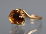 a close up of a gold ring with a brown stone