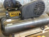 two air compressors sitting on a pallet in a warehouse