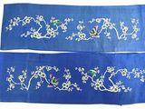 two pieces of blue cloth with birds and flowers on them