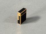 a close up of a small black and gold object on a table