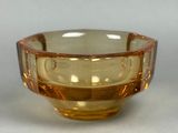 a yellow glass bowl with a brown rim on a table