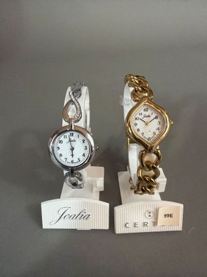 deux montres exposées sur une table, accompagnées d'une étiquette de prix