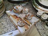 many plates and cups sitting on a counter top