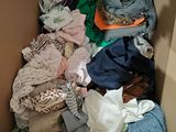 a cardboard box filled with clothes and a cat