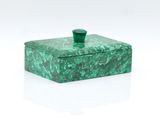 a green marble box with a green handle on a white surface