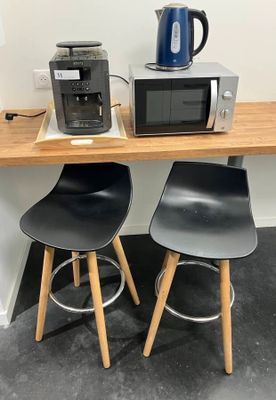 two stools and a microwave on a small table