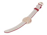 a close up of a watch on a white surface with a red band