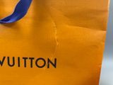 un sac jaune sur lequel est inscrit « Louis Vuitton »