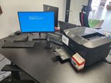 a printer sitting on a desk next to a monitor and keyboard