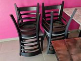 three wooden chairs sitting in front of a pink wall