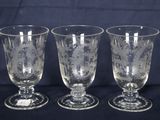 trois verres à pied en verre transparent posés sur une table noire