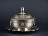 an antique silver plate with a lid on a black background