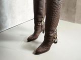 someone is wearing a pair of brown boots with tassels on them