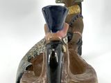 a ceramic figurine of a man riding a horse