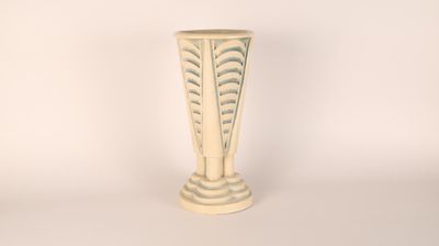 a white vase sitting on a table with a white background